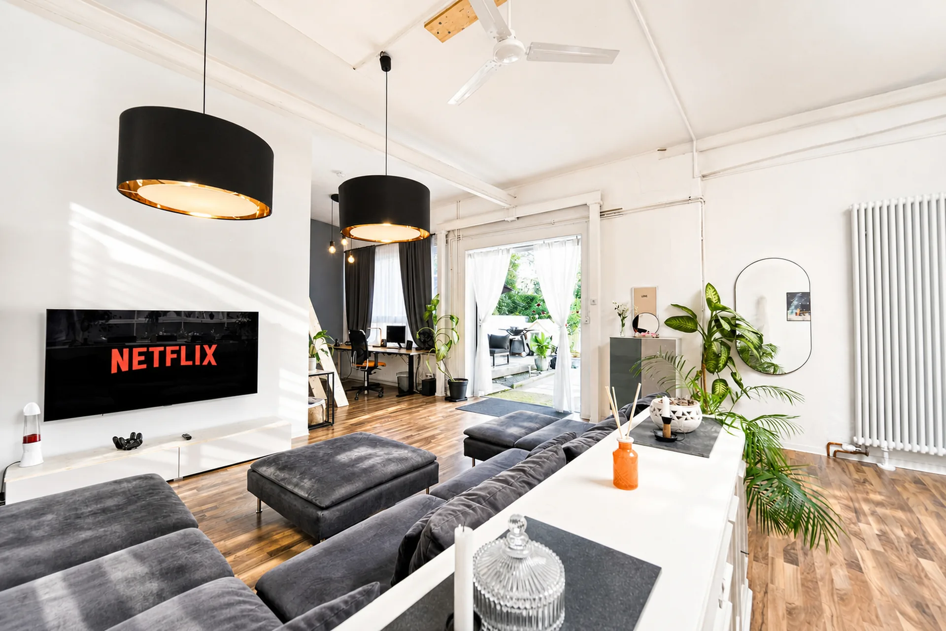 Heller Wohnbereich im Industrial-Loft mit Sofa und Smart-TV