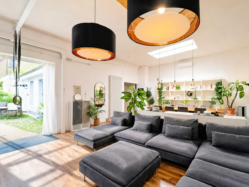 Heller Wohnbereich im Industrial-Loft mit Sofa und Smart-TV
